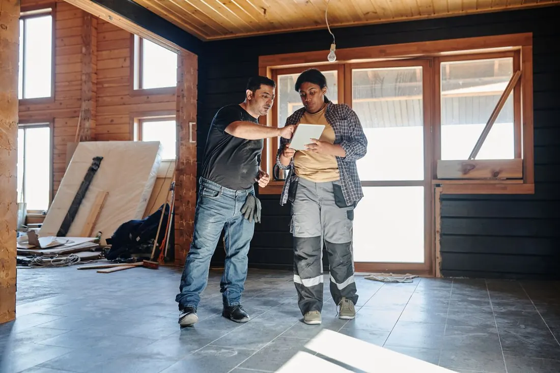 Contratista y supervisora revisando el avance en una tablet dentro de la obra